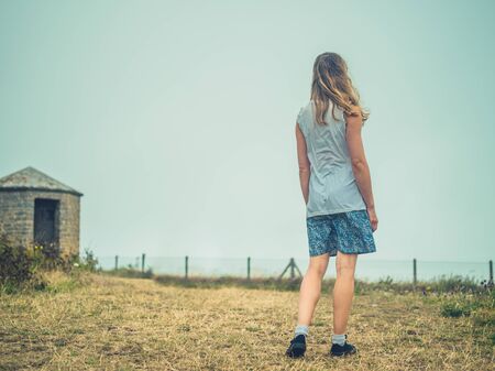 A young woman is walking in the fog on the coastの写真素材