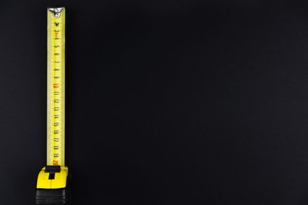 measuring tape measure in yellow on a black background