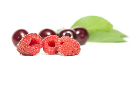 raspberries and cherries close up isolated on a white backgroundの写真素材