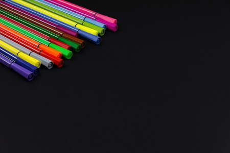 lots of new multi-colored markers on a black backgroundの写真素材