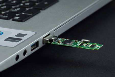 a flash card without a case inserted into a laptopの写真素材