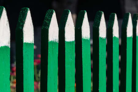 green wooden fence with white tips close-upの写真素材