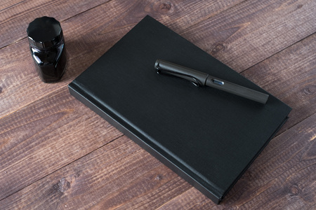 Fountain Pen, Notebook, Ink on wooden tableの写真素材