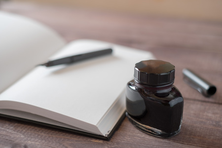 Fountain Pen, Notebook, Ink on wooden tableの写真素材