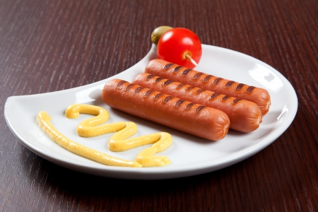Grilled wurstel on dish with mayonnaise and tomatoの写真素材