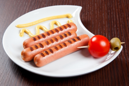 Grilled wurstel on dish with mayonnaise and tomatoの写真素材