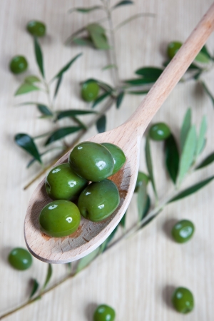 Olives in a wooden spoonの写真素材