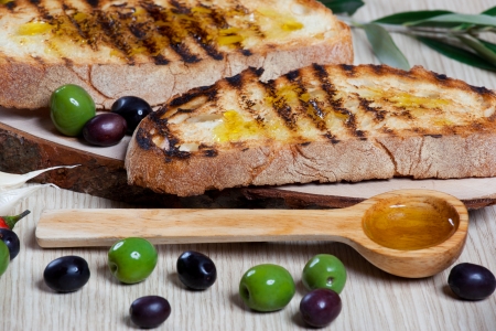 Italian bruschetta, olives and a wooden spoonの写真素材