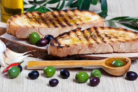Italian bruschetta and olives in a wooden spoonの写真素材