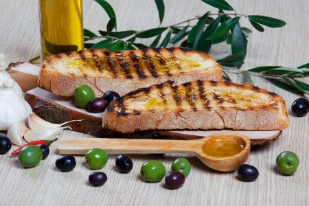 Italian bruschetta, olives and a wooden spoonの写真素材