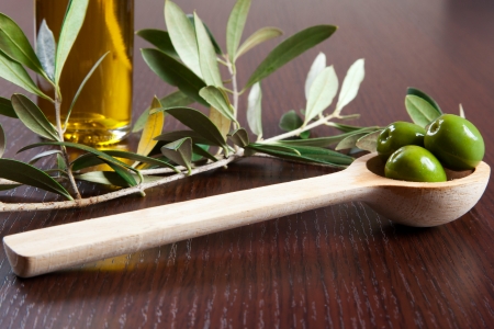 Green olives in a wooden spoonの写真素材