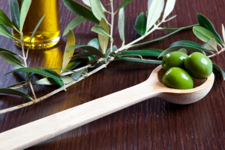 Green olives in a wooden spoonの写真素材