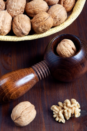 Walnuts and nutcracker in a wooden tableの写真素材