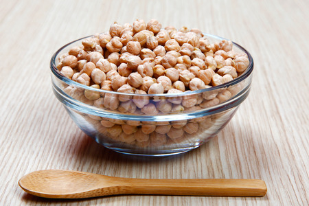 Chickpeas in a bowl on a wooden tableの写真素材