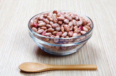 beans in a bowl on a wooden tableの写真素材