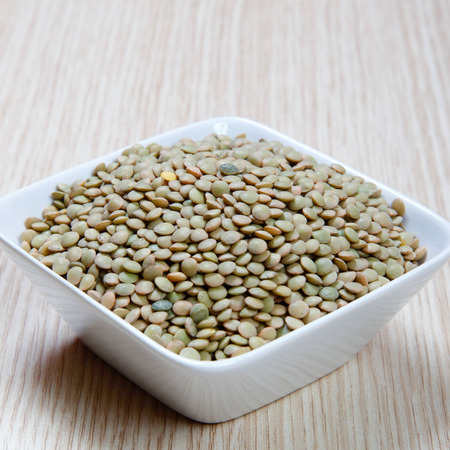 lentils in a bowl on a wooden tableの写真素材