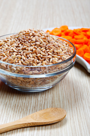 carrotes and dried spelt in a bowl on a tableの写真素材