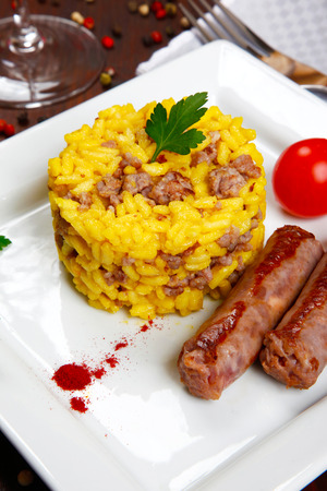 risotto with sausages and saffron in a dishの写真素材