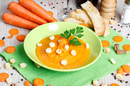 carrot soup in a green bowl on a tableの写真素材