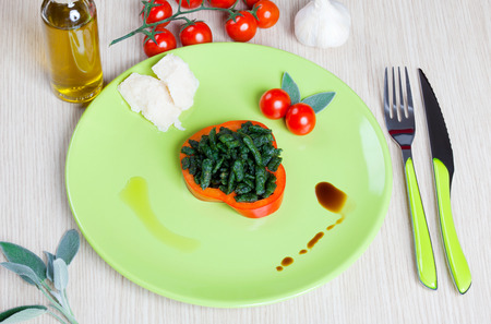 Spatzle small dumplings with spinach and tomatoes on a dishの写真素材