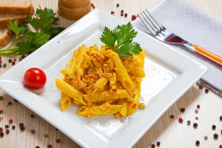 Penne with speck and saffron on a dishの写真素材