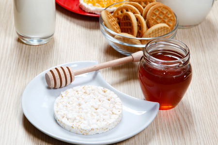 One waffle and honey on a tableの写真素材