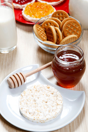 One waffle and honey on a tableの写真素材