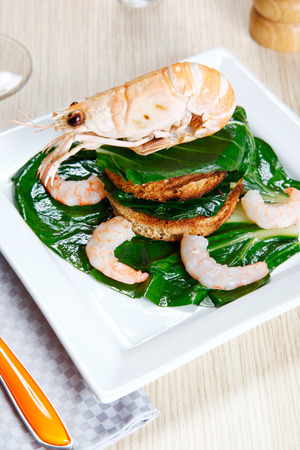 crayfish on a toast with vegetables on a dishの写真素材