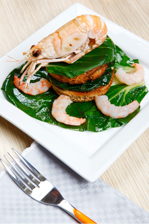 crayfish on a toast with vegetables on a dishの写真素材