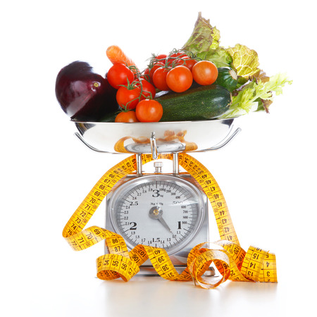 Fruits and vegetables on a balance isolated on a white backgroundの写真素材