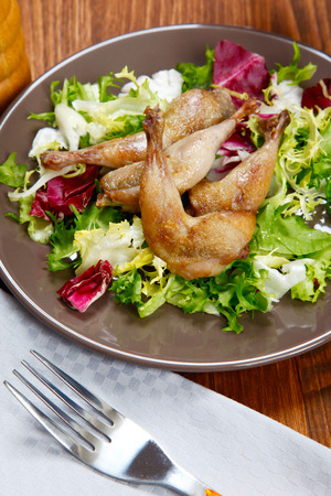 cooked quail and vegetables in a dishの写真素材