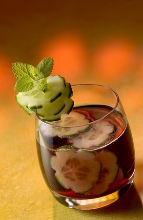 Pieces of cucumber in a coktail, surrounded by an orange ambience.の写真素材