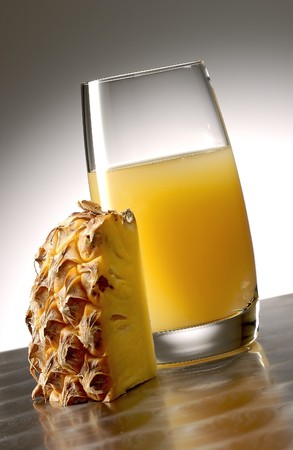 Pineapple juice with pineapple fruite on polished aluminum surface.の写真素材
