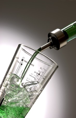 Pour gree liquid into a shaker, filled with ice cubes.の写真素材