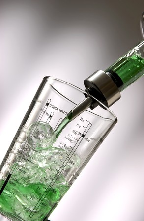 Pour gree liquid into a shaker, filled with ice cubes.の写真素材