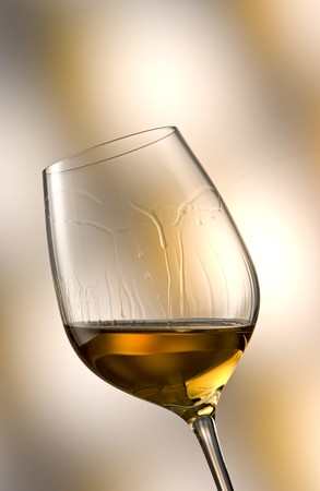 Glass of white wine in yellow-brown ambianceの写真素材