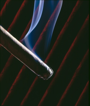 Light up a cigare, with smoke and moody background.の写真素材