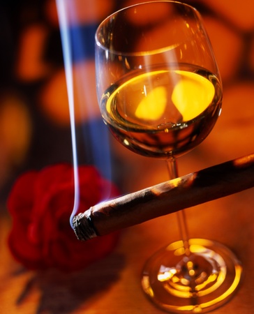 glass of wine with a cigar in a red ambienceの写真素材