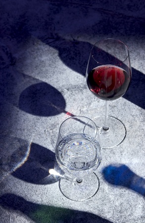 glasses of red wine and water with shadowsの写真素材