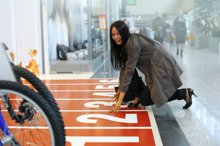 Beautiful young woman ready for a shopping spree at store entrance.の写真素材