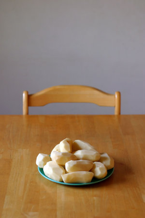 Peeled potatoes sitting on dinner tableの写真素材