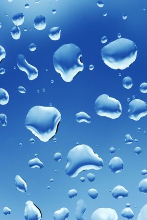 Water drops on glass over blue skyの写真素材