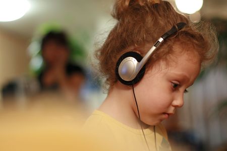 Little girl listening fairytale in headphones. Shallow DOF.の写真素材