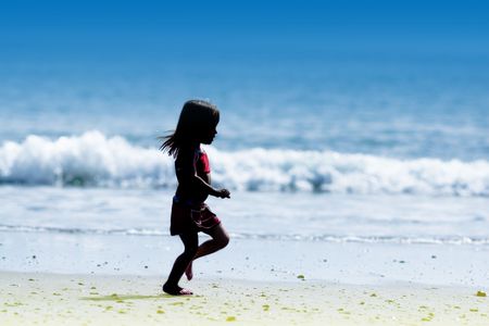 Little Girl Running By Blue Oceanの写真素材