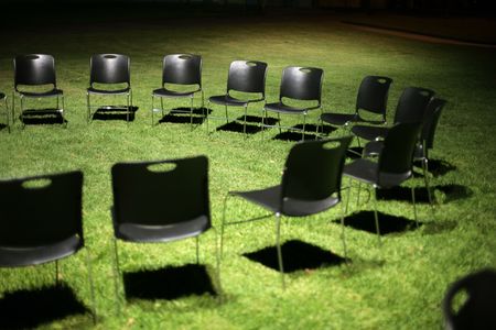 Circle of black chears on green grass at night. Shallow DOF.の写真素材