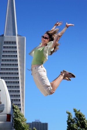 Young woman jumping in downtown San Franciscoの写真素材