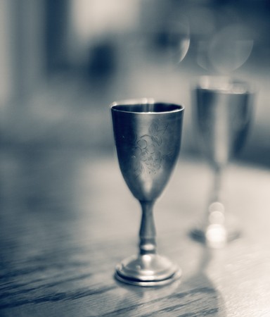 Two vintage metal wine glasses on table. High grain effect, shallow DOF.の写真素材