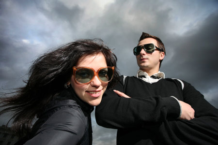 Cool young couple over dramatic cloudy sky