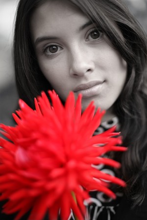 Beautiful woman with red flower. Close-up, shallow DOF, focus on eyes.の写真素材