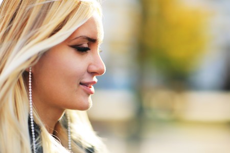 Beautiful blond woman outdoors. Close-up on profile, shallow DOF.の写真素材